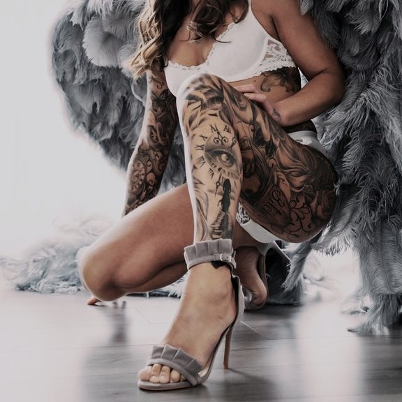 Lady with tattoo on her leg wearing angel wings