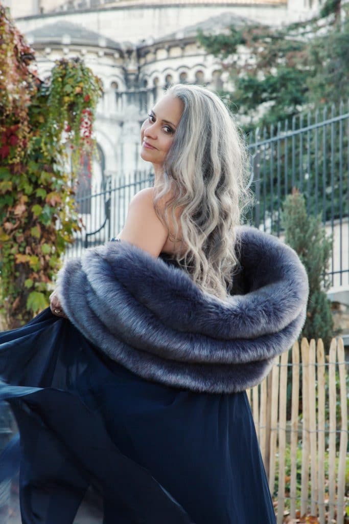 Elegant woman wearing faux fur jacket on location
